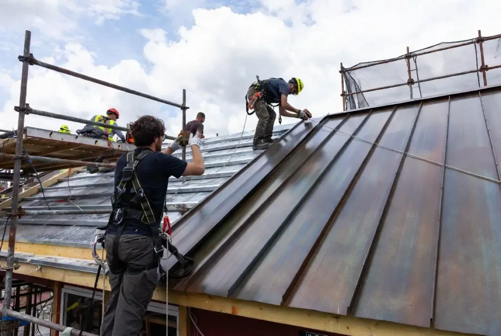 Labor working on standing seam metal roof