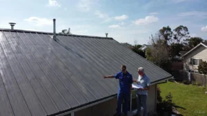A close-up view of a professionally installed dark gray aluminum roof, highlighting the vertical ribs used to calculate the standing seam metal roof cost per square foot for residential projects.