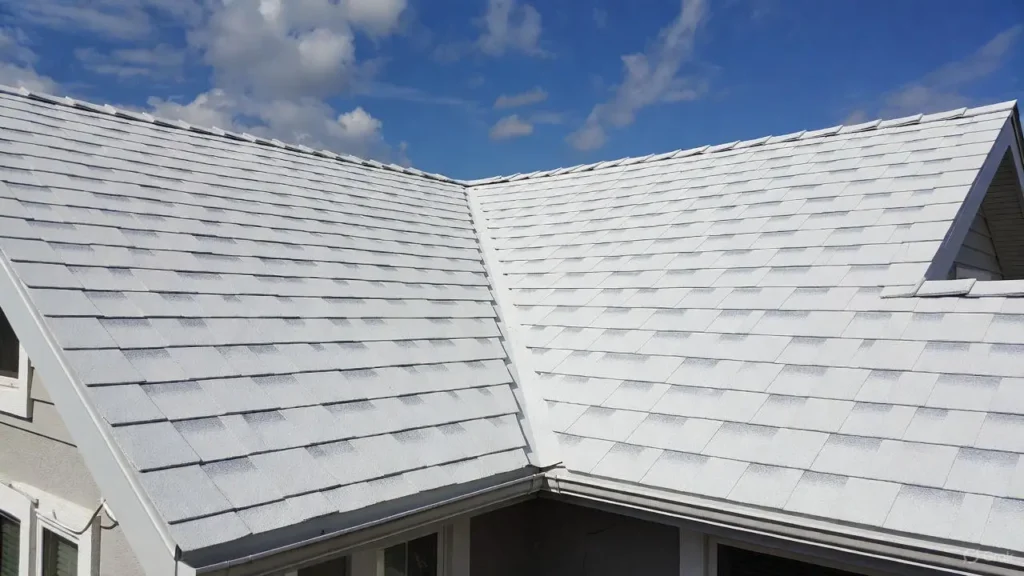 Professional installation of white rubber roofing (single-ply membrane) on a residential low-slope roof, featuring clean seams and reflective material under a blue sky.