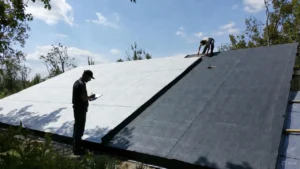 Professional roofing workers examining the contrast between white and black rubber roofing membranes, illustrating the comparison of White vs Black Rubber Roofing for commercial applications.